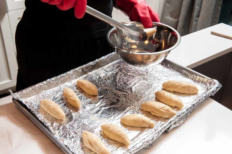 Dipping the pretzel breads in the lye solution.