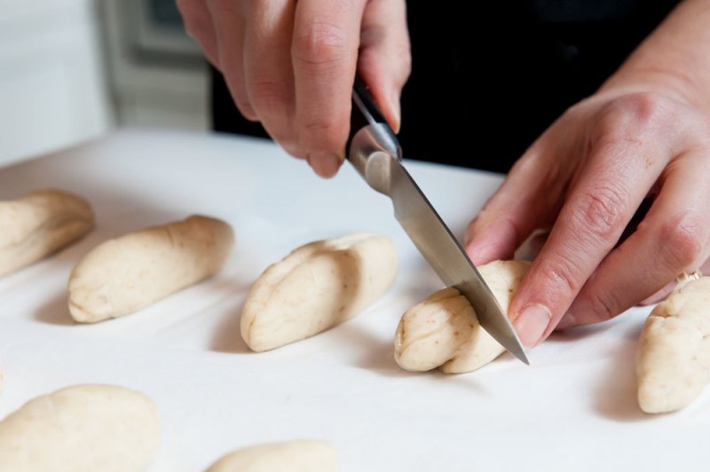 Slashing the pretzel breads.