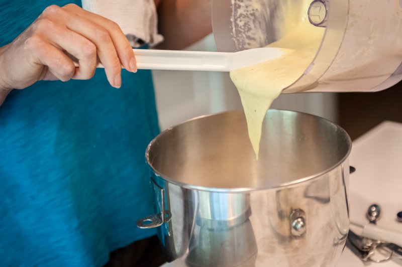 Pouring the liquid ingredients into the bowl of a stand mixer.