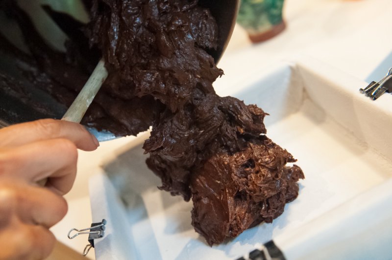 Brownie batter going into the prepared pan.