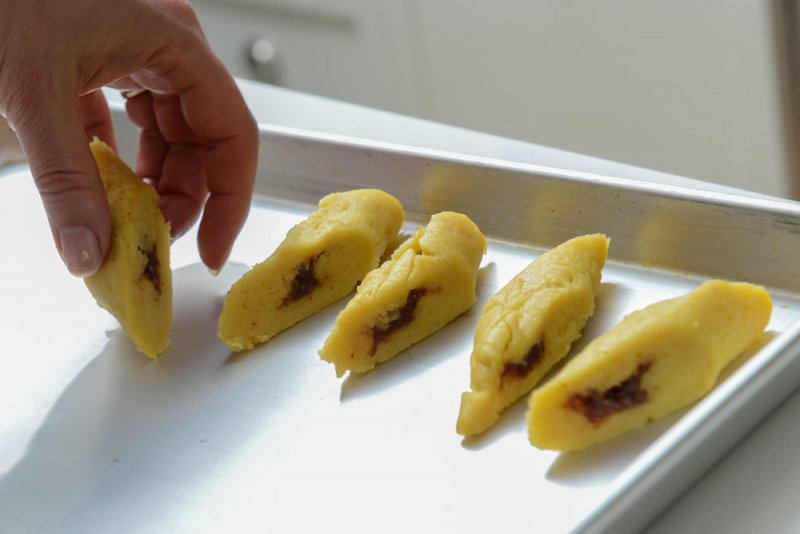 Transferring the cut Makroud to a tray.