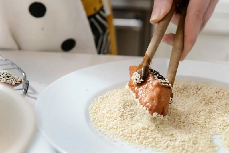 Dipping the fried Makroud in Sesame seeds.