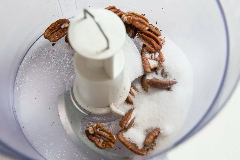 Combine sugar and pecans in the bowl of a food processor.