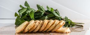 Lemon Cookies with White Chocolate and Mint stacked on a table with fresh mint.