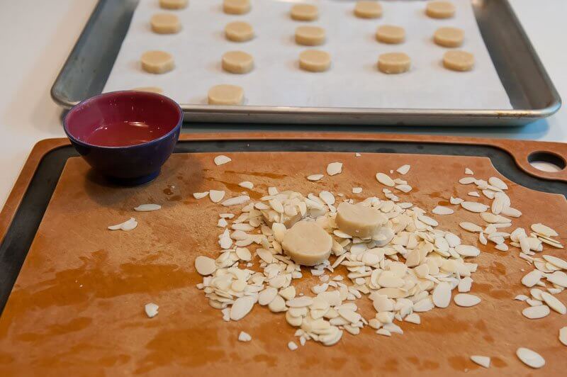 Coating the cookies with almonds.