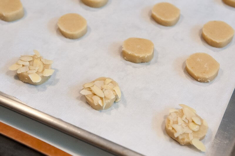 Coating the cookies with almond slices.