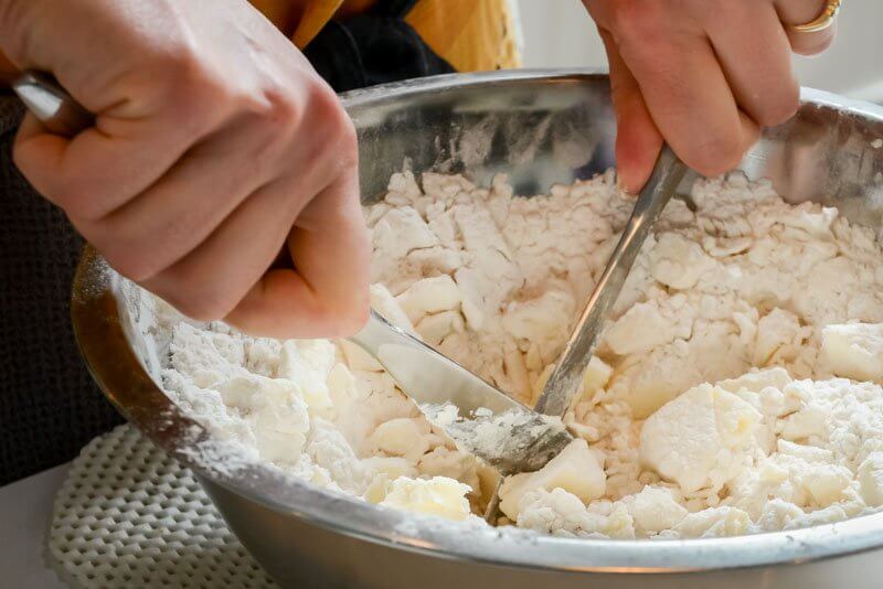 Cutting the butter into the flour and cream cheese.