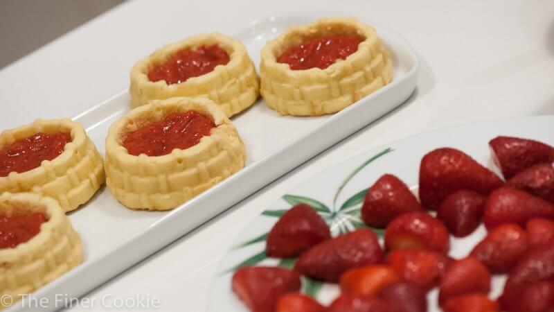 Laying the strawberry jam into the cakes.