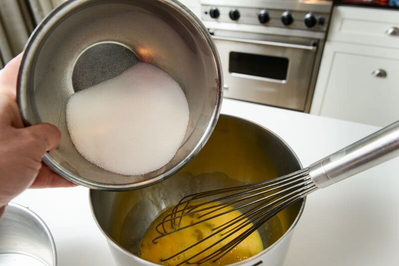 Adding sugar to the eggs.