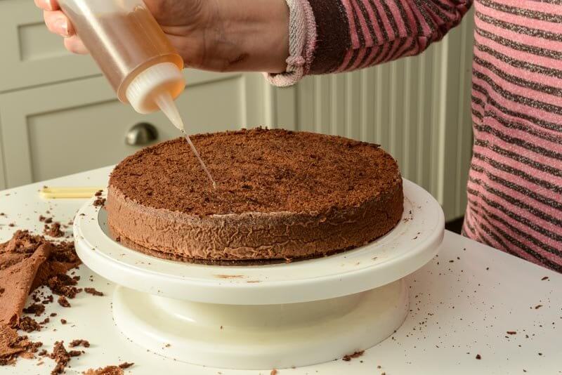 Adding syrup to the cake.