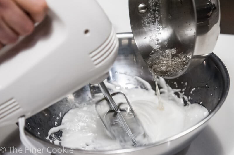 Adding the sugar syrup to the meringue.