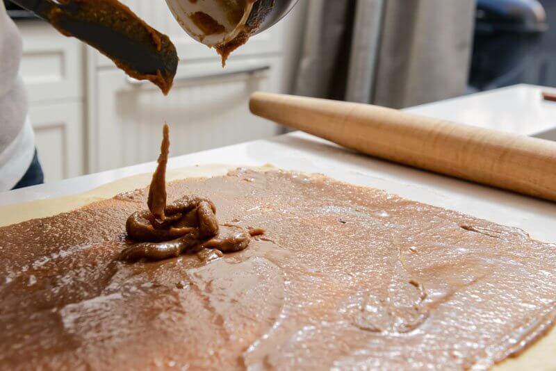 Spreading the almond filling on the rolled dough.