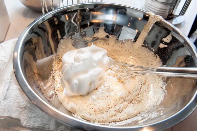 Adding the meringue to the batter and folding it with a flat whisk