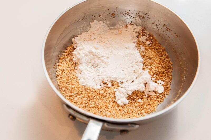 Adding the cake flour to the toasted almonds.