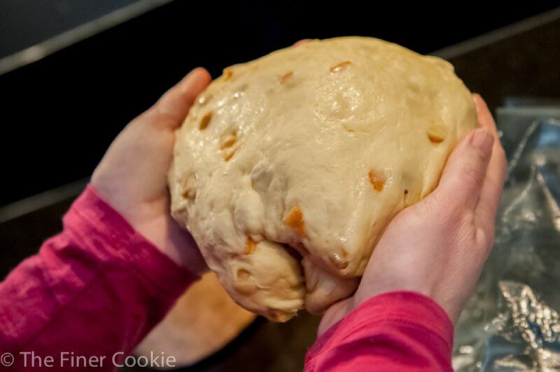 Dropping it into the panettone mould.