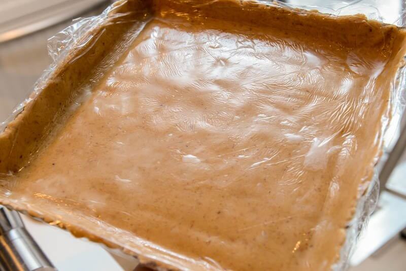 The Hazelnut Cookie dough spread into the tart pan with plastic wrap. Cool technique.