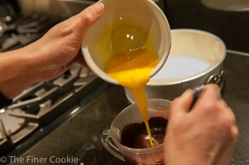 Adding the eggs to the chocolate mixture.