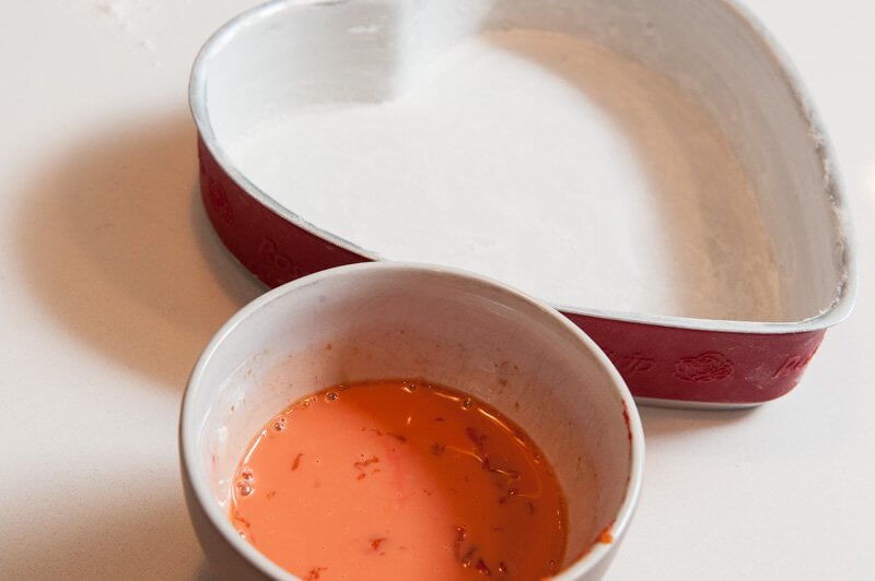 Prepared heart shaped pan with red food coloring in the egg yolks.