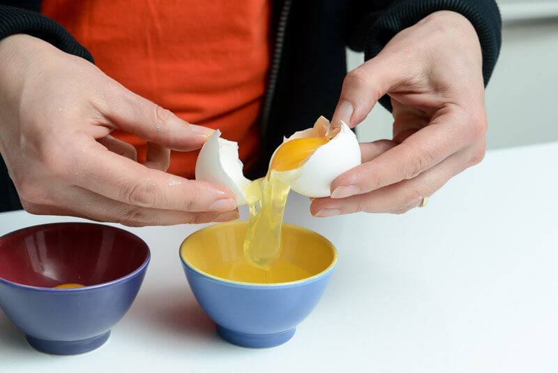 Separating the egg white from the yolk.