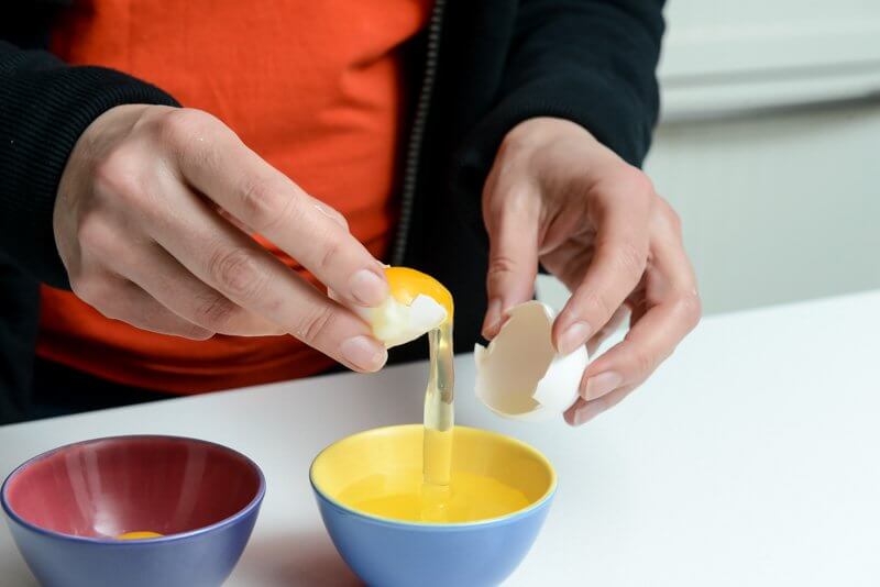 A gentle transfer of the egg yolk from shell to shell.