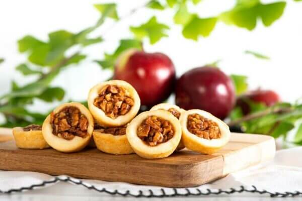 Apple pie cookies stacked on a cutting board