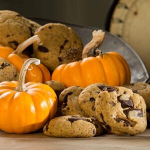 Pumpkin chocolate chip cookies in a bowl with small decorative pumpkins
