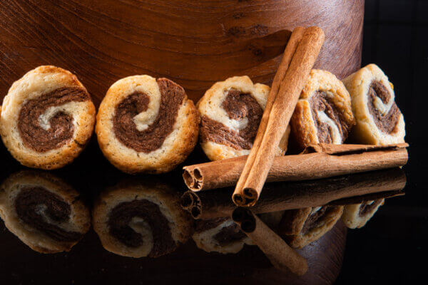 Cinnamon Roll Cookies placed on table with cinnamon sticks