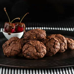 Chocolate Cherry Cookies with HAzelnuts on a black plate