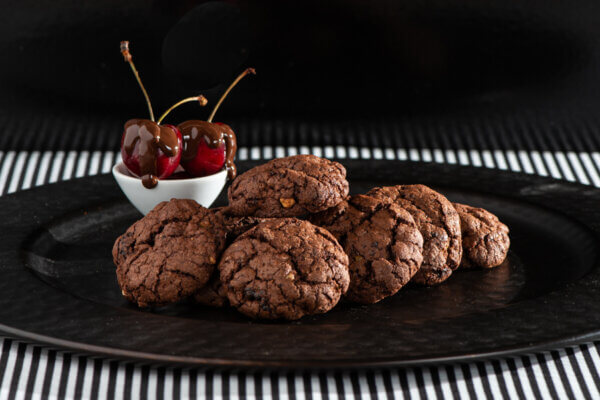 Chocolate Cherry Cookies with HAzelnuts on a black plate